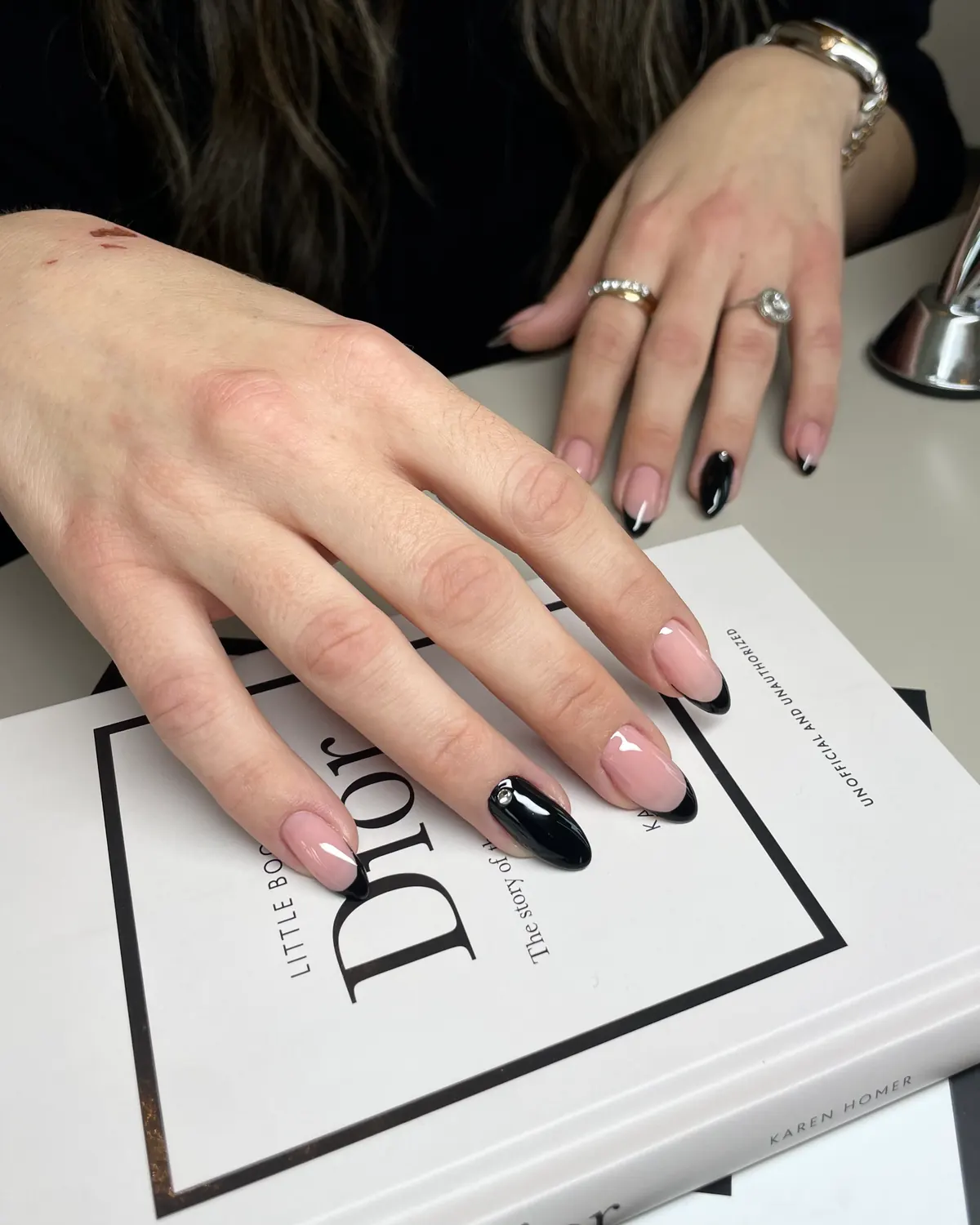 Mandelformede negle med sorte french-spidser og en sort accentnegl med en lille krystal - Beauty Hour Hellerup